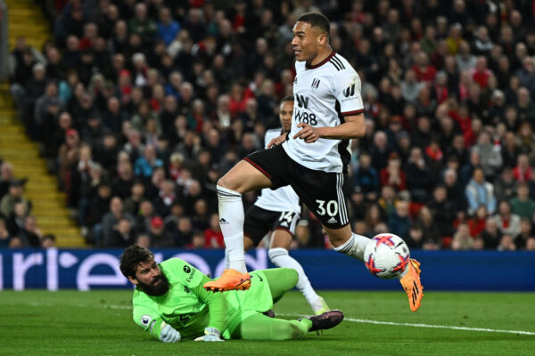 Fulham's Brazilian striker Carlos Vinicius (front C) controls the ball as he fights for it with Liverpool's Brazilian goalkeeper Alisson Becker (rear C) during the English Premier League football match between Liverpool and Fulham at Anfield in Liverpool, north west England on May 3, 2023. (Photo by Paul ELLIS / AFP) / RESTRICTED TO EDITORIAL USE. No use with unauthorized audio, video, data, fixture lists, club/league logos or 'live' services. Online in-match use limited to 120 images. An additional 40 images may be used in extra time. No video emulation. Social media in-match use limited to 120 images. An additional 40 images may be used in extra time. No use in betting publications, games or single club/league/player publications. / 